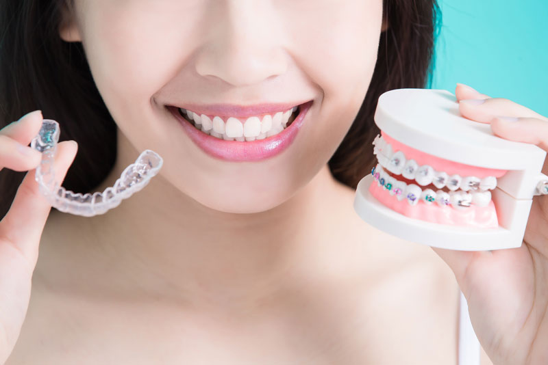 Dental Patient Smiling While Holding Up Her Invisalign